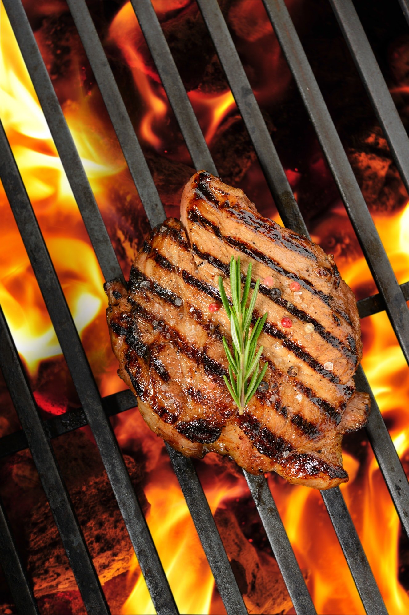 Grilled pork steak on the flaming grill